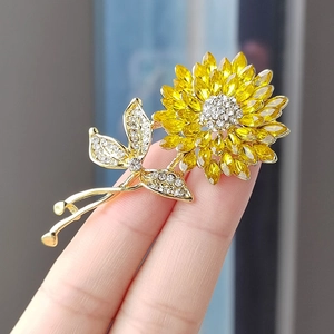 Vue macro détaillée d'une broche tournesol dorée avec cristaux jaunes et petits strass brillants