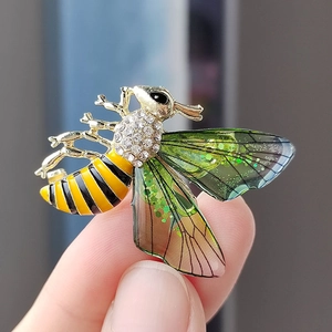 Detailansicht der Bienenbrosche mit gelb-schwarzer Emaille und grünen Flügeln