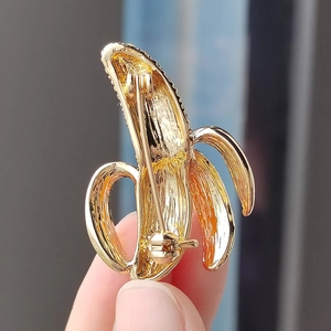 Detailed back view of a gold banana brooch with secure safety pin clasp closure