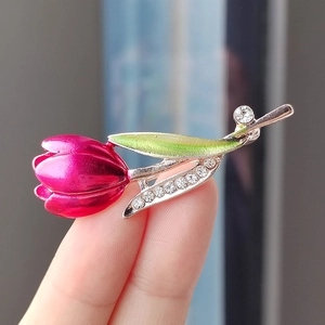 Detail of tulip brooch with pink enamel petals and sparkling rhinestones on green leaves