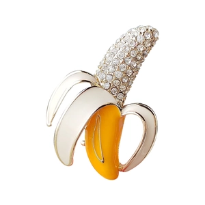 Cute banana brooch with sparkling rhinestones and white enamel in a gold alloy setting