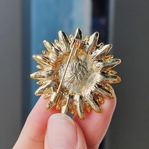 Vue arrière de la broche tournesol montrant l'épingle de sûreté et la texture dorée