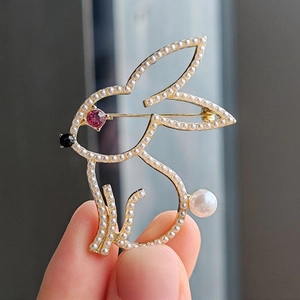 Cute bunny brooch in gold metal frame with white pearls and pink gemstone accents
