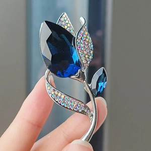 Spilla a fiore di lusso con cristallo blu profondo e strass iridescenti in argento