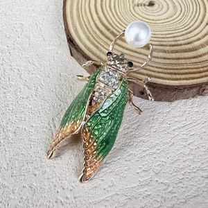 Exquisite gold cicada brooch with green enamel wings, rhinestones and a large white pearl