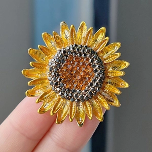 Magnifique broche tournesol aux pétales en métal jaune et centre en cristal scintillant