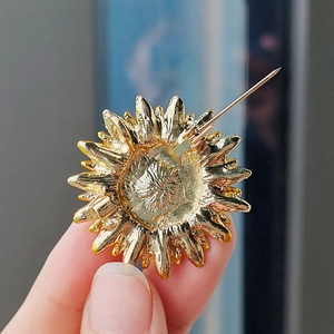 Détails du dos de la broche tournesol dorée avec fermoir sécurisé et texture métallique