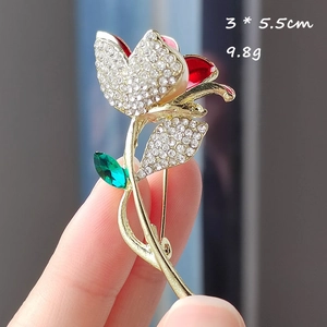 Détail d'une broche fleur de 3x5,5cm avec pétales en émail rouge et strass blancs