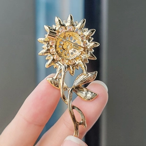Rückansicht einer goldenen Sonnenblumen-Brosche mit filigranen Blütenblättern und Sicherheitsnadel