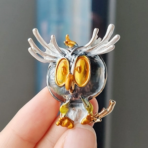Cartoon owl brooch in silver and gold alloy with vibrant yellow eyes and enamel details