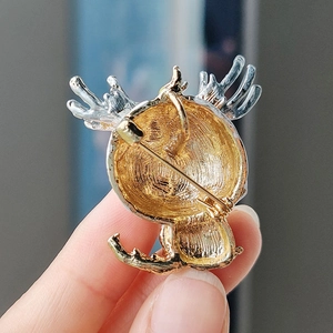 Detail of cartoon brooch back featuring dual-tone metal plating and secure safety clasp