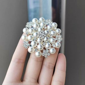 Close-up of elegant flower brooch with pearls and sparkling rhinestones for scarves