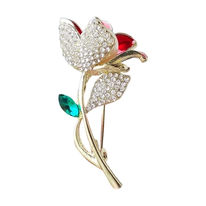 Broche fleur dorée avec pétales en émail rouge, strass blancs et accent de feuille verte