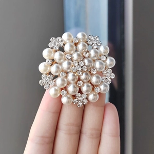Close-up of pearl and rhinestone floral brooch showing intricate detail and craftsmanship