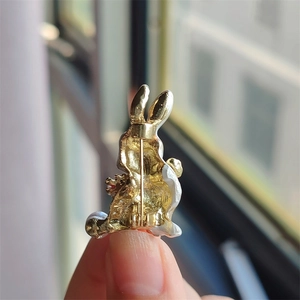 Detailed back view of a golden rabbit brooch showing the secure metal safety pin closure