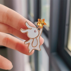 Detailed close-up of rabbit brooch with rose gold plating and white enamel finish