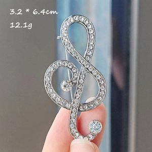 Detail shot of musical note brooch with sparkling crystals measuring 3.2 by 6.4 cm