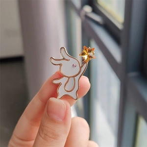 Detail of cute rabbit brooch with white enamel, rose gold plating and star crystal