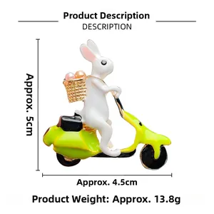 Detail of bunny riding green motorcycle brooch with enamel finish and pearl accents