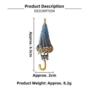 Detail of creative umbrella brooch with blue rhinestones and gold bow 6.5cm length