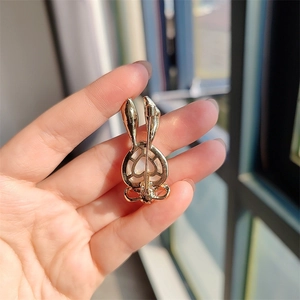 Detail view of the golden rabbit brooch back with pin clasp and heart-shaped element