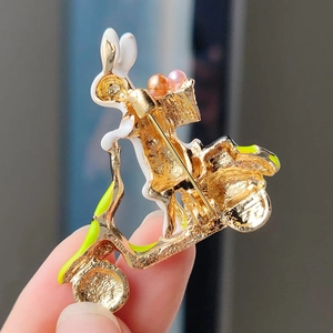 Cute rabbit on scooter brooch with gold plating, white enamel, and pearl accents