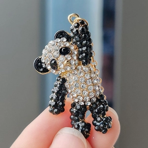 Détail macro d'une broche panda dorée ornée de strass noirs et transparents