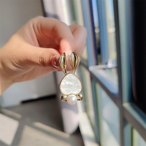 Detail of cute rabbit brooch with heart-shaped shell inlay and elegant white pearl