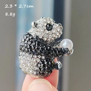 Détail montrant broche panda en cristal 2,3 x 2,7 cm et poids 8,8 g sur la main