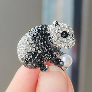 Broche panda scintillante avec strass et perle blanche tenue à la main