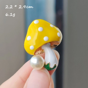 Detailed view of a yellow mushroom enamel brooch with white pearls and 2.2*2.9cm dimensions