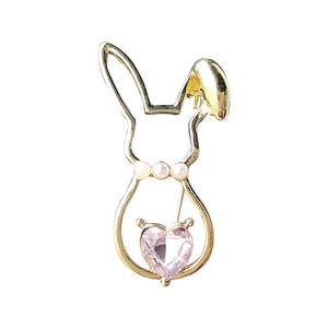 Golden rabbit brooch with pink heart crystal and white pearls on white background