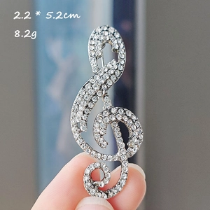 Detailed size view of silver treble clef music note brooch with sparkling rhinestones