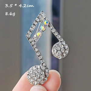 Detail view of musical note brooch with crystals, size 3.5x4.2cm and weight 8.6g