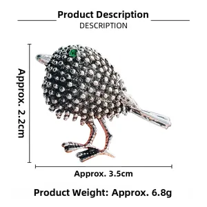 Detail view of sparrow brooch dimensions 2.2cm by 3.5cm with green rhinestone eye