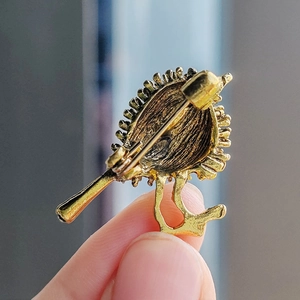 Detailed back view of vintage gold bird brooch showing pin clasp and metal texture
