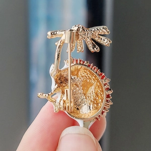 Detail of the golden alloy hedgehog brooch back with safety pin fastening and enamel edges