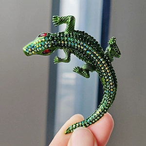 Sparkling crystal-encrusted crocodile brooch featuring green and red gradient rhinestones