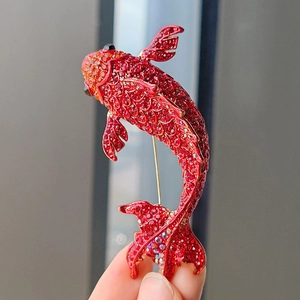 Close-up of red rhinestone koi fish brooch with gold finish and pin closure detail