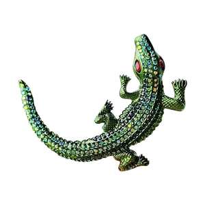 Green crystal encrusted crocodile brooch with sparkling red eyes on a white background