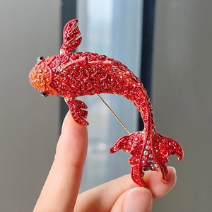 Detailed view of red koi fish brooch with yellow rhinestones and gold-plated pin back