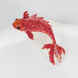 Close-up of red and orange koi fish brooch with rhinestones and metal pin detail