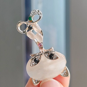 Close-up of cat eye stone fox brooch with sparkling pink and green rhinestones