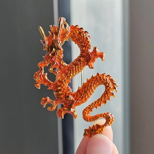 Artistic amber-orange dragon brooch with gold edges and detailed texture for fashion