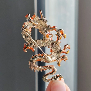 Detailed macro view of the gold-plated dragon brooch reverse with secure pin clasp