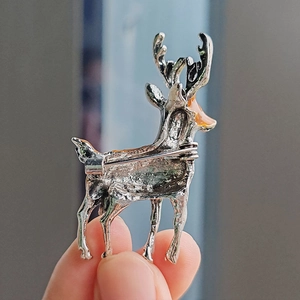 Fashionable silver alloy elk brooch with orange enamel accents and a pin clasp