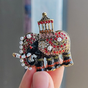 Elegant elephant brooch with black enamel, colorful crystals, and golden pavilion details