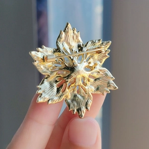 Vue arrière d'une broche perle fleurie dorée montrant l'épingle et la texture du métal
