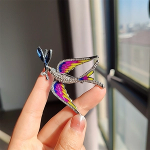 Macro shot of blue enamel swallow brooch featuring vibrant rhinestones and silver finish