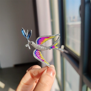 Close-up of blue enamel swallow brooch with sparkling rhinestones and gradient wings